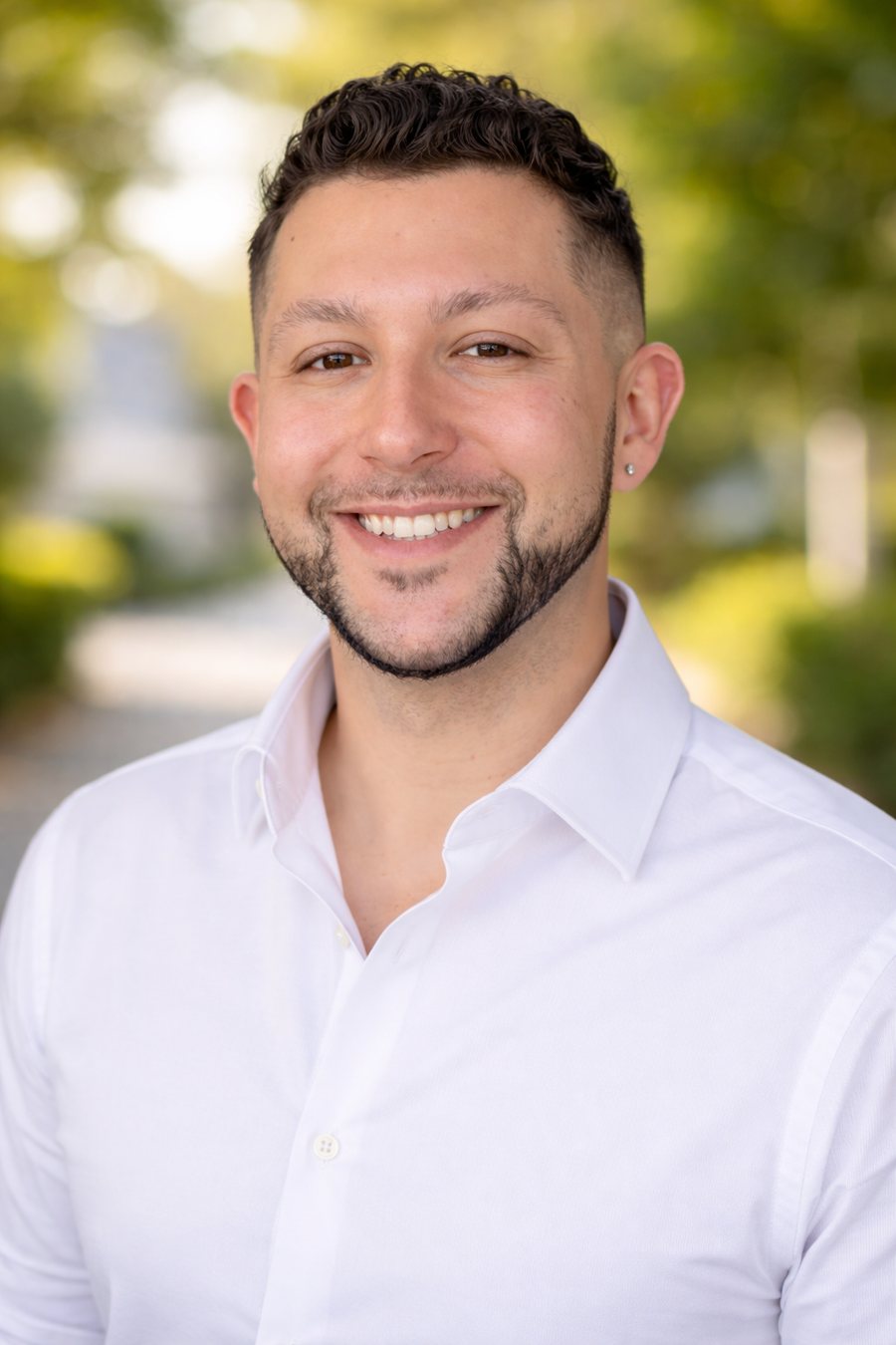 Antonio Gonzalez smiling outdoors in a white button-up shirt